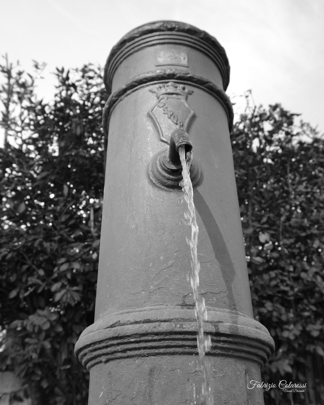 A ridosso della riserva naturale della Cervelletta Via Martinelli – Colli Aniene È una fontanella come tante. Eppure è un punto di passaggio fondamentale. Mentre la fotografavo, due ragazzi in assetto da trekking si sono fermati a riempire le borracce prima di entrare nel Parco della Cervelletta. Nessuna scena eroica. Solo un gesto necessario. Da una parte la città. Dall’altra la campagna romana che resiste dentro la Riserva Naturale Valle dell'Aniene, con i suoi sentieri e il suggestivo Castello della Cervelletta che emerge nel verde. Quei sentieri non sono lì per caso. C’è stato un uomo che ha dedicato parte della sua vita a mantenerli vivi: Domenico Pietrangelli, per tutti “Mimmo Cervelletta”. Ha tracciato percorsi, organizzato tour, custodito questo pezzo di natura quando il caos della città sembrava avere la meglio. Oggi sempre più persone cercano silenzio e natura. È una buona notizia. Ma riscoprire significa anche rispettare. Forse dovremmo ricordarci che luoghi come la Cervelletta non si mantengono da soli. Hanno bisogno di cura. Hanno bisogno di presenza. E quella fontanella, apparentemente anonima, è il punto in cui tutto questo comincia.